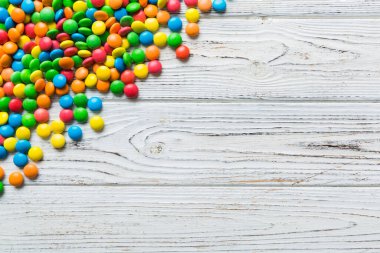 Renkli arka planda karışık renkli şeker koleksiyonu. Düz yerde, üst tarafta. Renkli çikolata kaplı şeker çerçevesi.