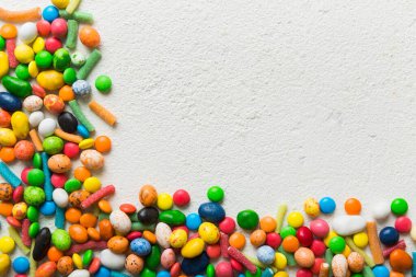 Renkli arka planda karışık renkli şeker koleksiyonu. Düz yerde, üst tarafta. Renkli çikolata kaplı şeker çerçevesi.