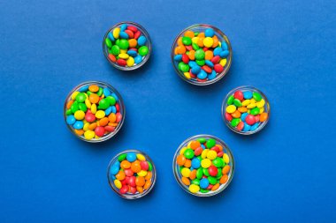 farklı renkte yuvarlak şekerler ve kavanozlar. Fotokopi alanı olan büyük çeşitlilikteki şeker ve şekerlerin üst görünümü.