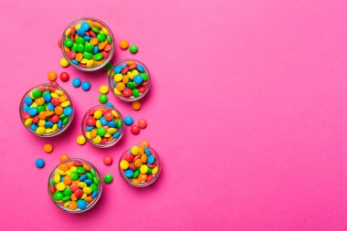 farklı renkte yuvarlak şekerler ve kavanozlar. Fotokopi alanı olan büyük çeşitlilikteki şeker ve şekerlerin üst görünümü.