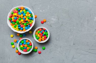 farklı renkte yuvarlak şekerler ve kavanozlar. Fotokopi alanı olan büyük çeşitlilikteki şeker ve şekerlerin üst görünümü.