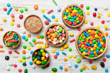 farklı renkte yuvarlak şekerler ve kavanozlar. Fotokopi alanı olan büyük çeşitlilikteki şeker ve şekerlerin üst görünümü.