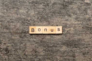 Tahta blokta bonus kelime yazıyor. Masada bonus metin, konsept.