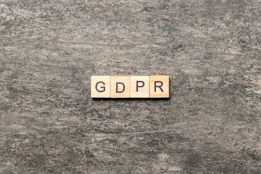 Tahta blokta GDPR kelimesi yazıyor. Genel Veri Koruma Yönetmeliği metni desing, konsept için çimento tablo üzerinde.