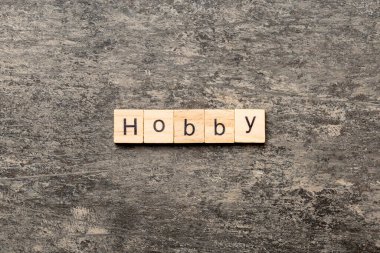 Tahta blokta yazan Hobby kelimesi. Çimento masasındaki HOBBY metni desing, konsept için.