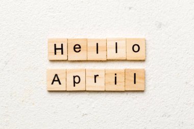 Merhaba Nisan kelimesi tahta blokta yazılı. Merhaba Nisan metni masa, konsept.