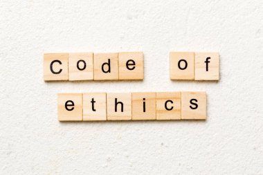 code of ethics word written on wood block. code of ethics text on table, concept.