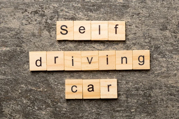 Self-driving car word written on wood block. Self driving car text on cement table for your desing, concept.