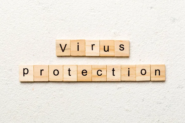 Virus protection word written on wood block. Virus protection text on cement table for your desing, concept.
