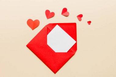 Renkli arka planda beyaz kart ve kalp olan kırmızı kağıt zarf. Top view Sevgililer Günü konsepti.