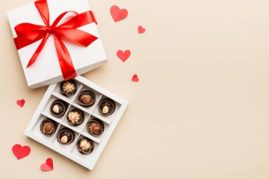 Sevgililer Günü için kırmızı kutuda lezzetli çikolatalı pralinler. Kalp şeklinde çikolata kutusu, fotokopi alanı ile üst görünüm..