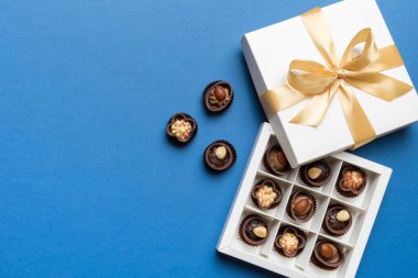 Çikolata ve altın bantlı beyaz kutu. Kopyalama alanı olan üst görünüm.