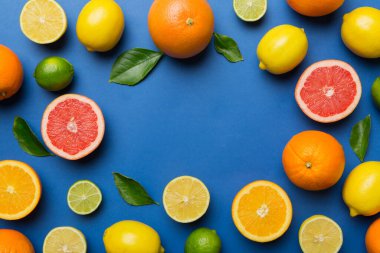 Limon, portakal ve limon gibi açık renkli arka planda limon ağacı yapraklı turunçgiller bir çerçeve oluşturuyor. Sağlıklı metin kavramı için boşluk.