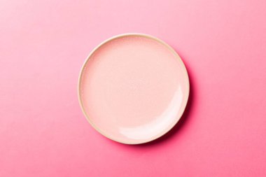 Renkli arka planın üst görüntüsü. Yemek için boş pembe tabak. Tasarımınız için alanı olan boş tabak.