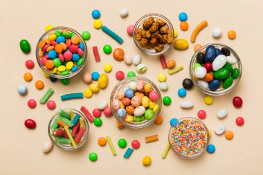 farklı renkte yuvarlak şekerler ve kavanozlar. Fotokopi alanı olan büyük çeşitlilikteki şeker ve şekerlerin üst görünümü.