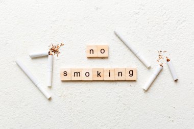 Sigara ve tahta bloklar, masa arkasında kırık sigara kum saati ile tütün günü yok, saat sağlığı konsepti. Sigarayı bırakma zamanı..