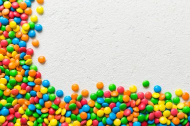 Renkli arka planda karışık renkli şeker koleksiyonu. Düz yerde, üst tarafta. Renkli çikolata kaplı şeker çerçevesi.