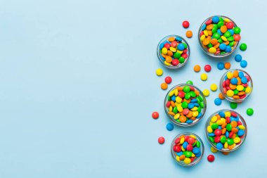 farklı renkte yuvarlak şekerler ve kavanozlar. Fotokopi alanı olan büyük çeşitlilikteki şeker ve şekerlerin üst görünümü.