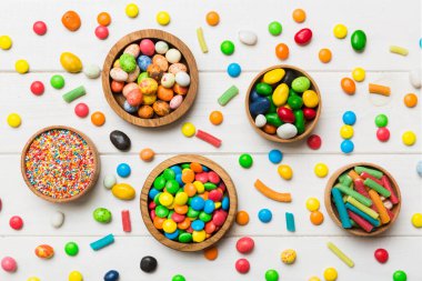 farklı renkte yuvarlak şekerler ve kavanozlar. Fotokopi alanı olan büyük çeşitlilikteki şeker ve şekerlerin üst görünümü.