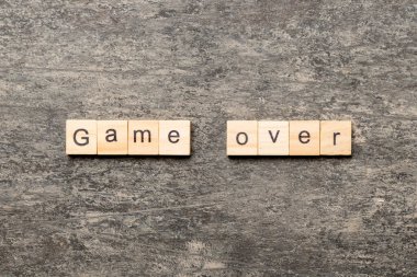 Tahta blokta yazılı oyun bitti. Masada oyun üzeri metin, konsept.