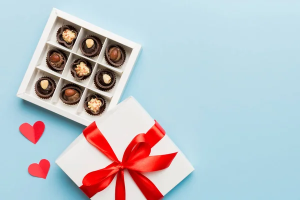 Delicious chocolate pralines in red box for Valentine's Day. Heart shaped box of chocolates top view with copy space.