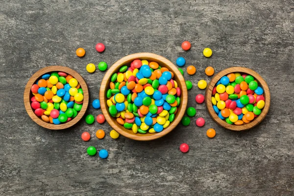 different colored round candy in bowl and jars. Top view of large variety sweets and candies with copy space.