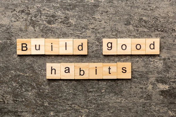 Build good habits word written on wood block. Build good habits text on table, concept.