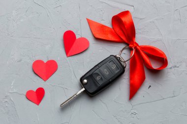Kırmızı kurdeleli ve renkli masada kalbi olan araba anahtarı. Sevgililer Günü ya da Noel hediyesi vermek, Kopya Alanı ile Üst Görünüm.