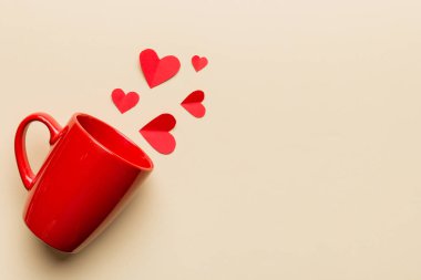 Renkli arka planda kırmızı bardak, kırmızı küçük kalpler, kopya alanı ile üst görünüm.