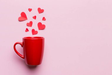 Renkli arka planda kırmızı bardak, kırmızı küçük kalpler, kopya alanı ile üst görünüm.