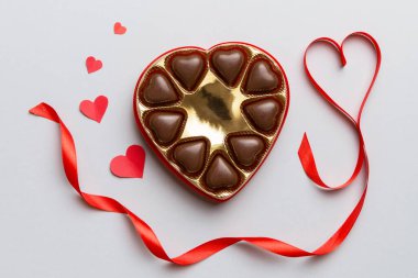 Sevgililer Günü için kırmızı kutuda lezzetli çikolatalı pralinler. Kalp şeklinde çikolata kutusu, fotokopi alanı ile üst görünüm..