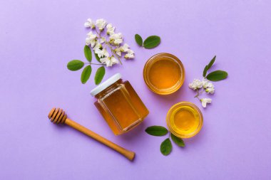 Akasya çiçekli ve yapraklı bal kavanozu. Taze bal üst görünüm düz yatıyordu.