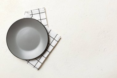 Renkli arka planda üst görünüm yiyecek için masa örtüsü üzerindeki boş yuvarlak gri tabak. Tasarımınız için boşluk olan peçeteye boş tabak.