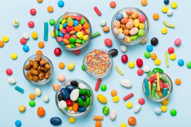 farklı renkte yuvarlak şekerler ve kavanozlar. Fotokopi alanı olan büyük çeşitlilikteki şeker ve şekerlerin üst görünümü.