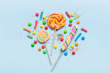 Lezzetli İştah açıcı Parti Aksesuarları Mutlu Yıllar Tatlı. Renkli arkaplanda farklı tipte şekerler, kopyalama alanı. Renkli doğum günü partisi geçmişi.