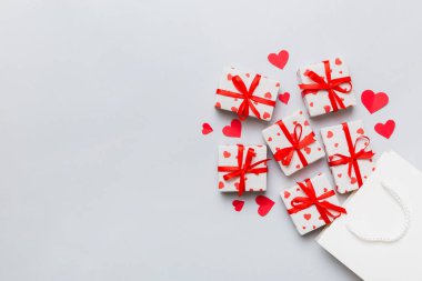 Gift boxes pop out from paper bag top view on colored background. bag packing handmade boxes fall out Concept of holidays, shopping, sale, discounts. Top view, flat lay.