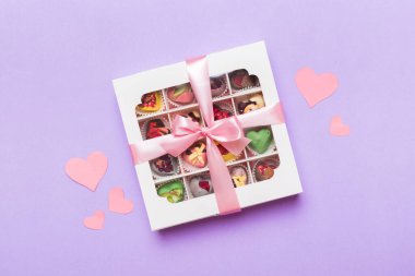 Valentine day composition: sweet candy, with gift boxes with bow and red felt hearts, photo template, background. Top View with copy space.
