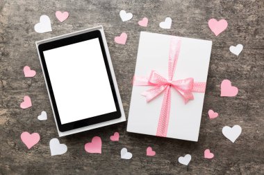 Gift box of open tablet for the holidays with a bow top view.