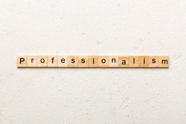 Ahşap blokta yazan profesyonellik kelimesi. Desing, konsept için çimento masadaki profesyonellik metni.