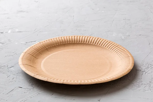 Perspective view of eco paper plate on cement background. Empty space for your design.