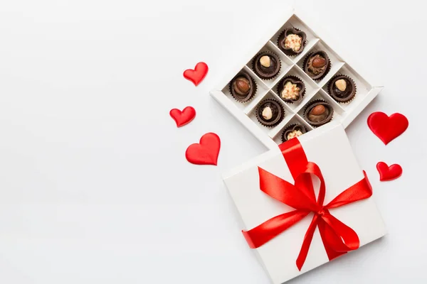 Delicious chocolate pralines in red box for Valentine\'s Day. Heart shaped box of chocolates top view with copy space.
