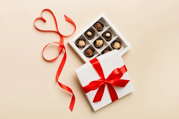 Delicious chocolate pralines in red box for Valentine's Day. Heart shaped box of chocolates top view with copy space.