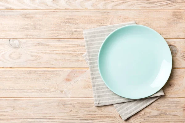 Renkli arkaplanda üst görünüm yiyecek için mavi tabak üzerinde boş. Tasarımınız için boşluk olan peçeteye boş tabak.