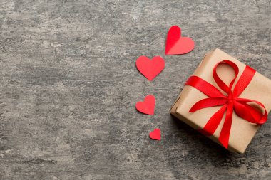 Sevgililer Günü kompozisyonu: Yay ve kalple kırmızı hediye kutusu. Noel hediyesi. Yukarıdan bak. Mesaj için yer var. Holday tebrik kartı.