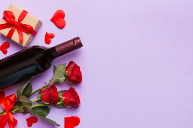 Kırmızı şarap, gül çiçeği ve hediye kutusuyla Sevgililer Günü kompozisyonu. Üst manzara, düz yatış. Tatil kavramı.