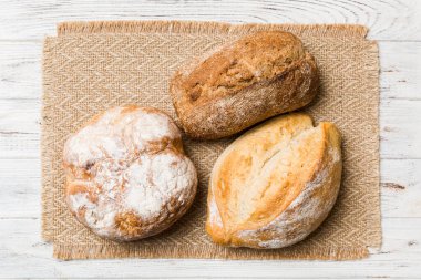 Kırsal masa manzaralı peçeteli taze pişmiş ekmek çeşitleri. Sağlıklı mayasız ekmek. Fransız ekmeği.