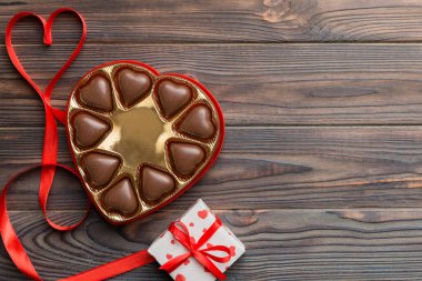 Sevgililer Günü için kutuda lezzetli çikolatalı pralinler. Kalp, hediye kutusuyla şekillendirilmiş çikolatalar fotokopi alanı ile üst görünüm.