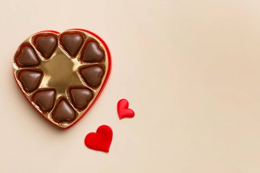 Sevgililer Günü için kırmızı kutuda lezzetli çikolatalı pralinler. Kalp şeklinde çikolata kutusu, fotokopi alanı ile üst görünüm..