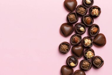 Renkli masa üzerinde farklı çikolata çeşitleri var. Kopya alanı ile Üst Görünüm ve Düz Yatay.