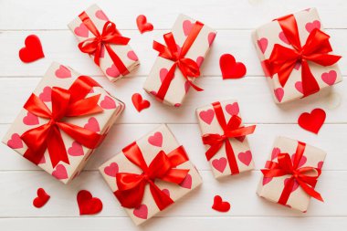 Top view photo of valentine day decorations gift box with red ribbon bow on colored background. Holiday gift boxes with top view.